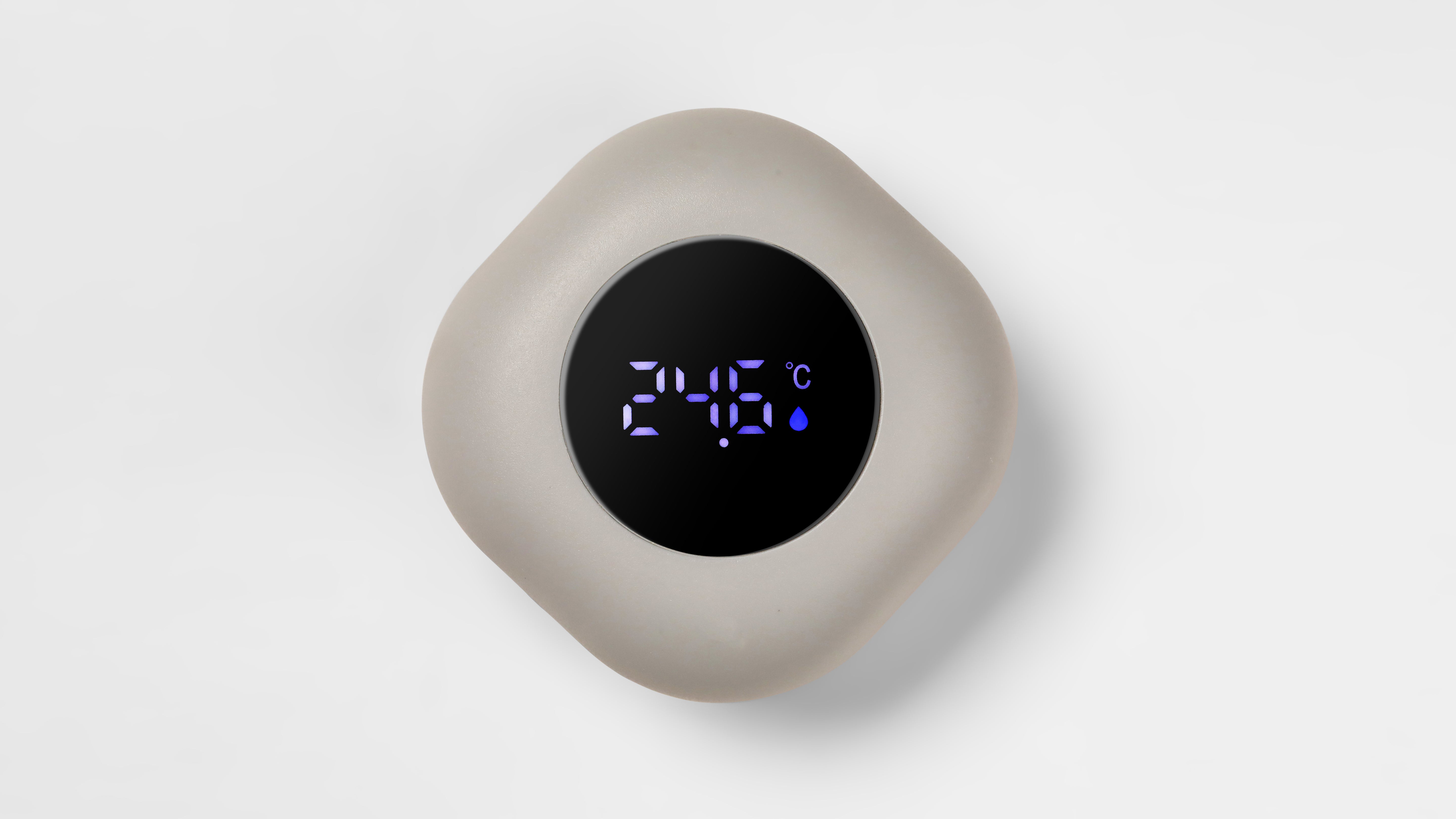‌A gray, rounded water thermometer for bathtubs, featuring a digital display showing the temperature in degrees Celsius.